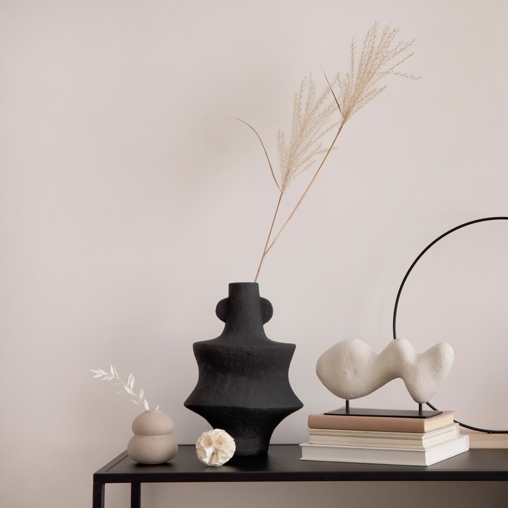 Déco Minimaliste Moderne : Vase Noir et Sculpture Abstraite Décoration minimaliste avec vase noir, herbe de la pampa, sculpture abstraite et livres sur une console moderne.